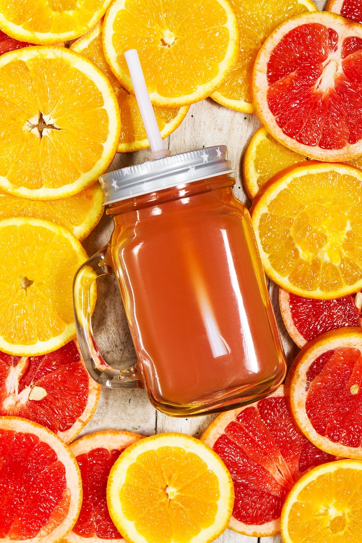Free Photo glass jug with a straw and oranges cut around