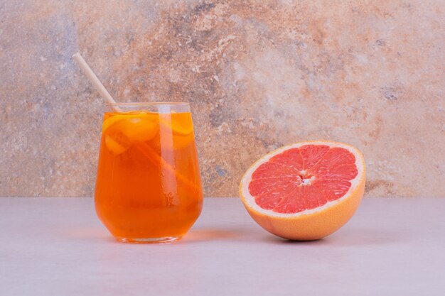 A glass of juice with citrus fruits inside