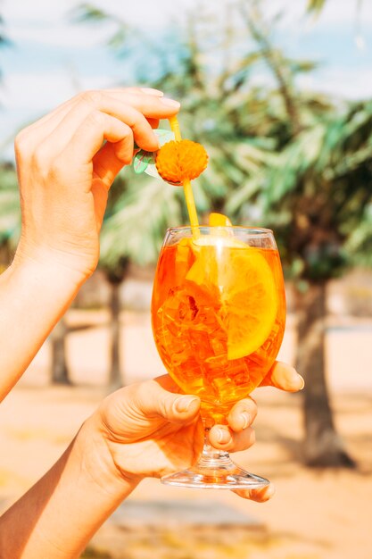 Glass of juicy tasty orange drink in hands
