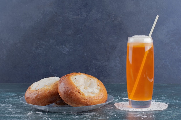 Un bicchiere di limonata e panini al formaggio sul tavolo di marmo.