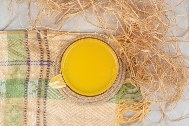 Glass of lemonade with lemon slice on tablecloth