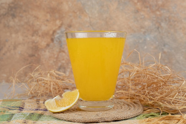 Glass of lemonade with lemon slice on tablecloth