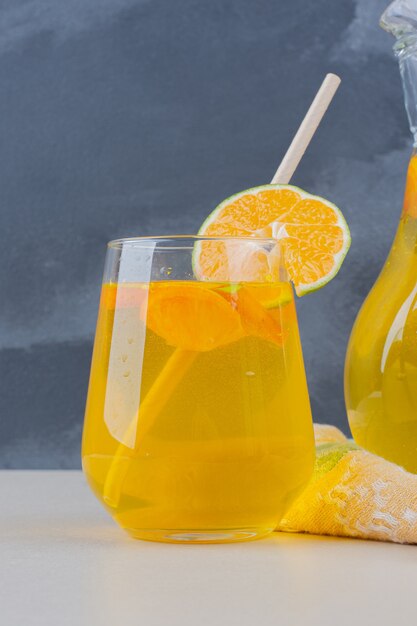 白いテーブルにレモンスライスとレモネードのグラス。