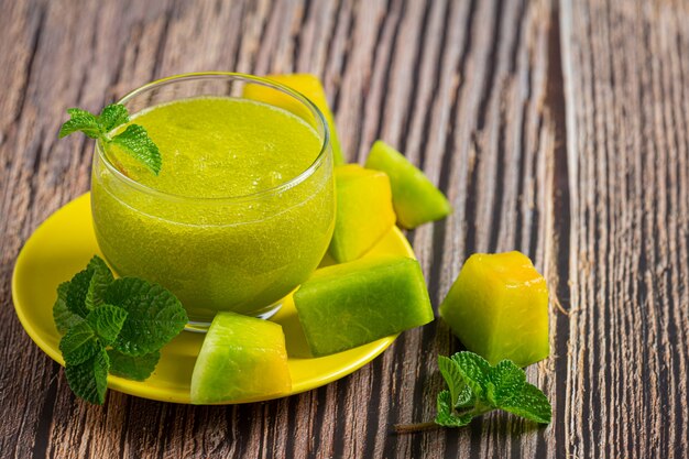 glass of melon juice put on wooden floor