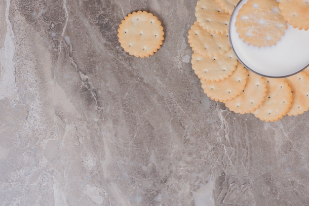 Glass of milk and biscuits marble table.