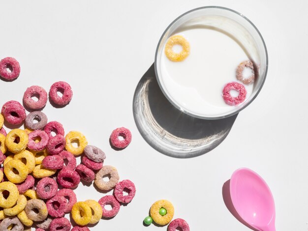 Glass of milk and cereal on white background