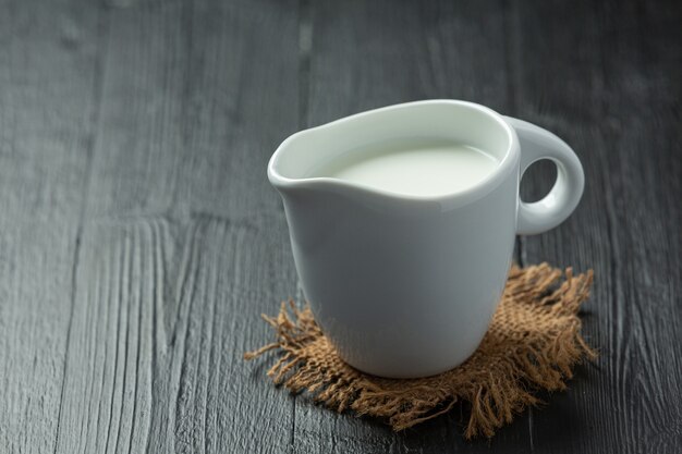 Glass of milk on dark wooden surface