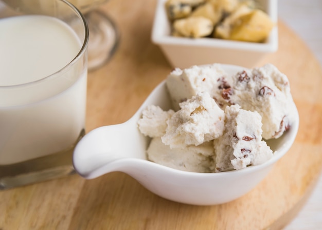 Glass of milk near plate with fresh cheese