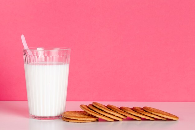 Стакан молока с вкусным печеньем, вид спереди