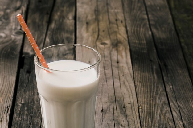 glass of milk with an orange drinking straw