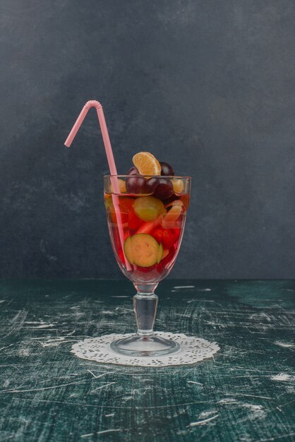 Glass of mixed fruit juice on marble table.