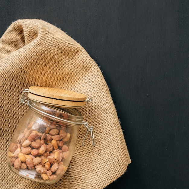 Glass of nuts on fabric texture