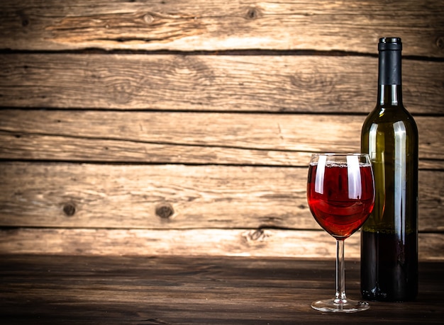 テーブル​の​上​の​赤ワイン​の​グラス​。​木製​の​背景​に​。