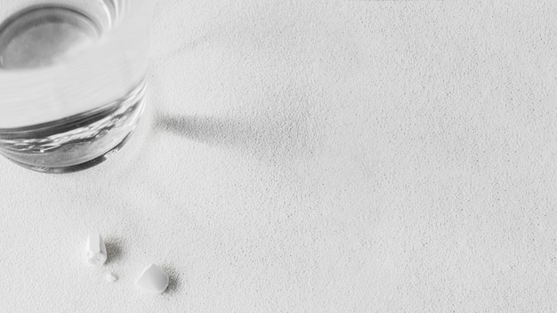 Бесплатное фото Стакан воды со сломанной белой таблеткой
