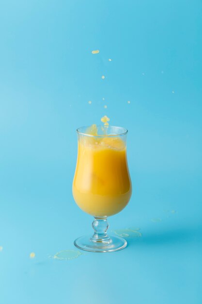 オレンジジュースと青い背景のガラス