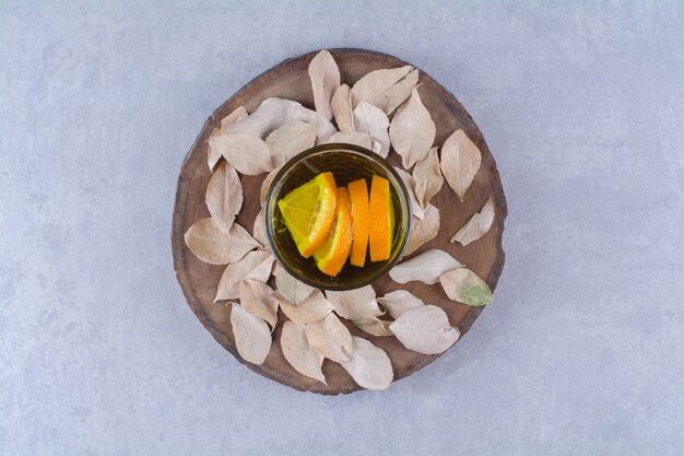 A glass of orange juice on a board , on the marble background.