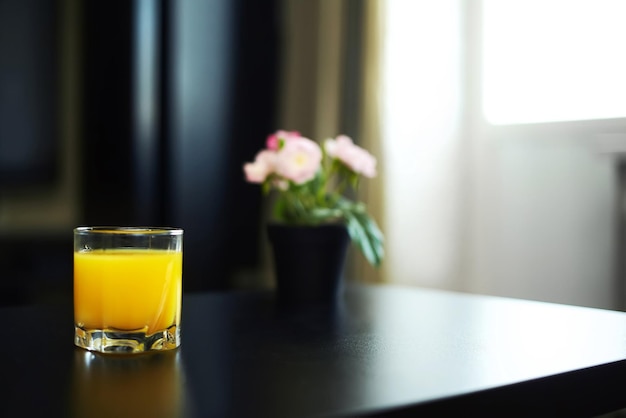 暗いインテリアのオレンジジュースのガラス