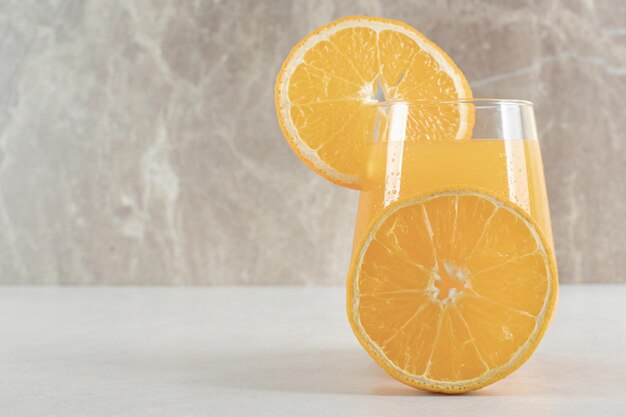 회색 테이블에 오렌지 주스 한 잔
