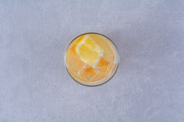 大理石のテーブルにオレンジジュースのグラス。