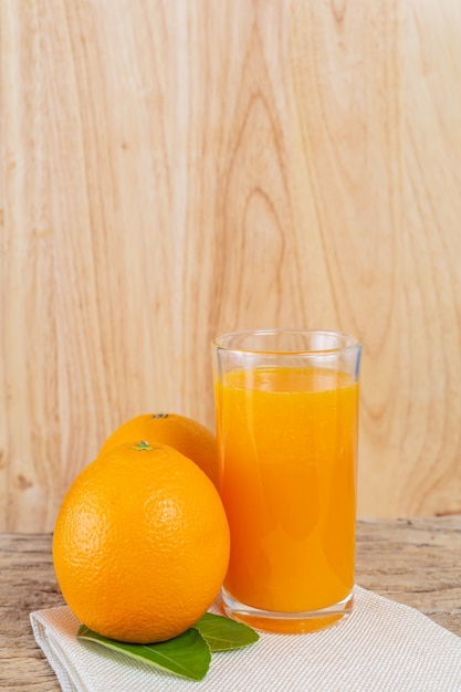 Foto gratuita bicchiere di succo d'arancia posto su legno.