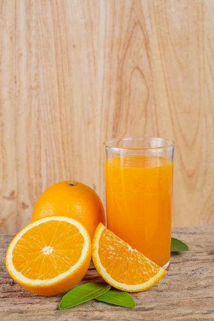 Glass of orange juice placed on wood.