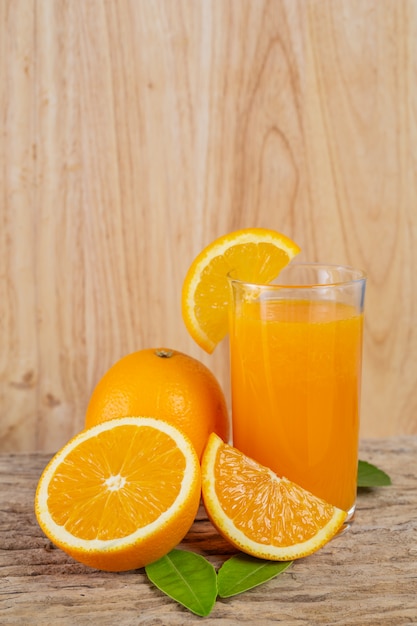 Glass of orange juice placed on wood.