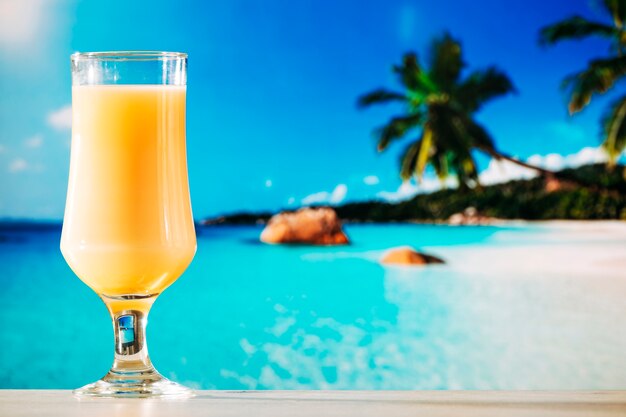 Glass of orange juice in tropical summer