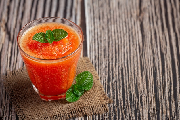 glass of papaya juice put on wooden floor