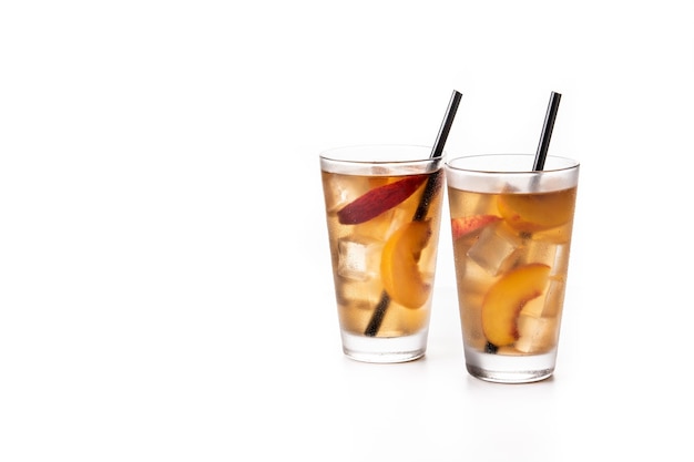 Glass of peach tea with ice cubes isolated on white background