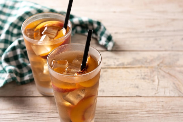 Glass of peach tea with ice cubes