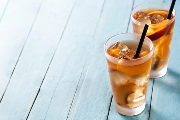 Glass of peach tea with ice cubes