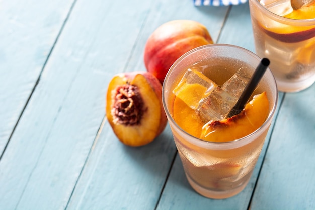 Glass of peach tea with ice cubes