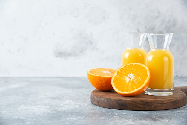 Free photo glass pitchers of juice with slice of orange fruit .