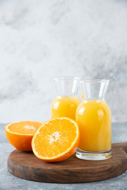 Glass pitchers of juice with slice of orange fruit .