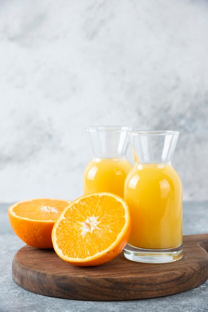 Glass pitchers of juice with slice of orange fruit .