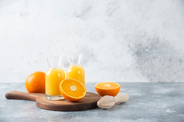 Glass pitchers of juice with slice of orange fruit .