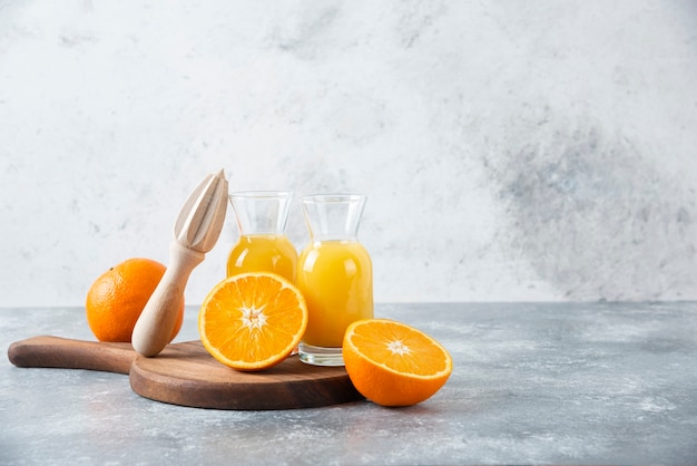 Glass pitchers of juice with slice of orange fruit .