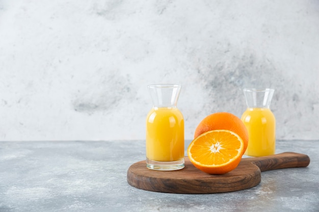 Glass pitchers of juice with slice of orange fruit .