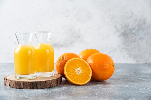 Glass pitchers of juice with slice of orange fruit .