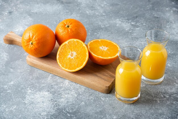 Glass pitchers of juice with slice of orange fruit .