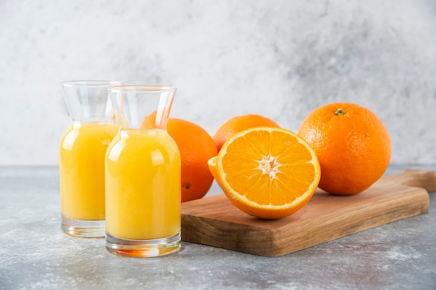 Glass pitchers of juice with slice of orange fruit .