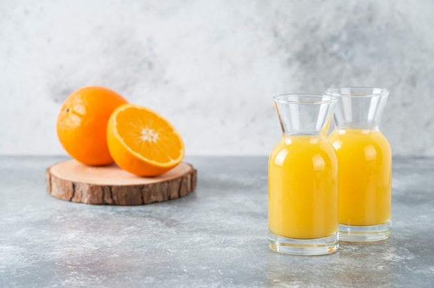 オレンジ色の果物のスライスとジュースのガラスピッチャー。
