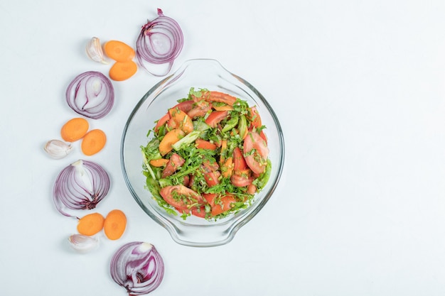 Foto gratuita un piatto di vetro di deliziosa insalata di verdure.
