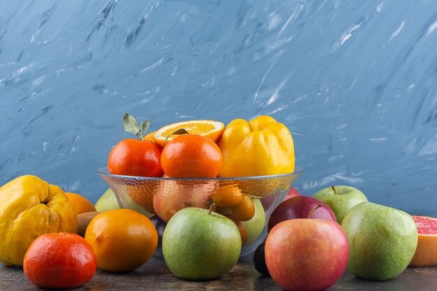 Glass plate of fresh fruits on top of many fruits.