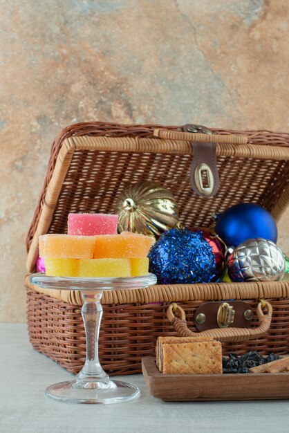 A glass plate full of sugar marmalade and Christmas festive balls on marble background. High quality photo