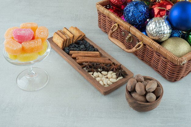 A glass plate full of sugar marmalade and Christmas festive balls on marble background. High quality photo