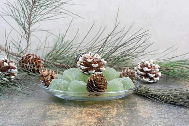 A glass plate of green marmalade and pinecones. High quality photo