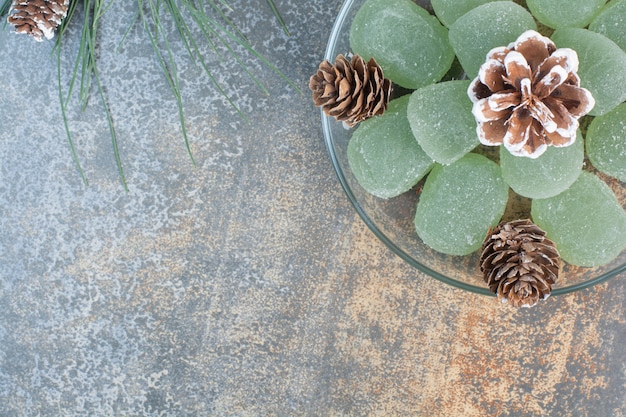 A glass plate of green marmalade and pinecones. High quality photo