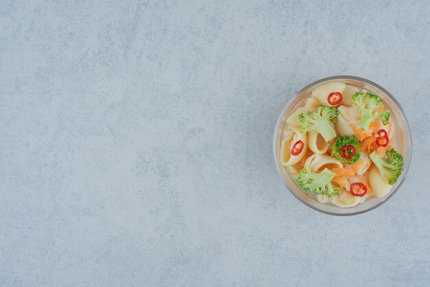 A glass plate of macaroni and broccoli on white background. High quality photo