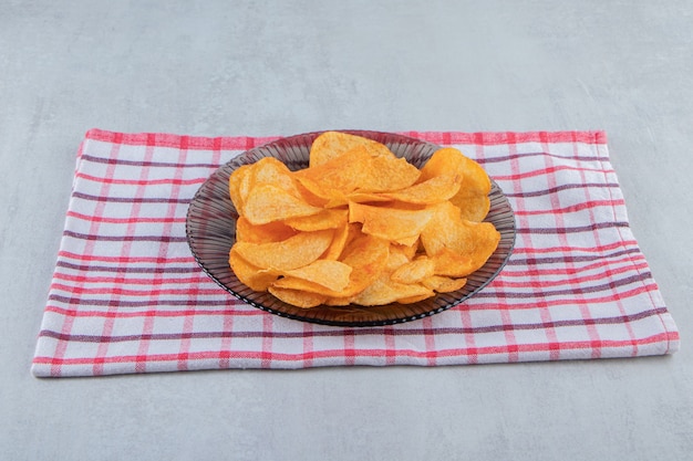 Free photo glass plate of spicy chips placed on stone.